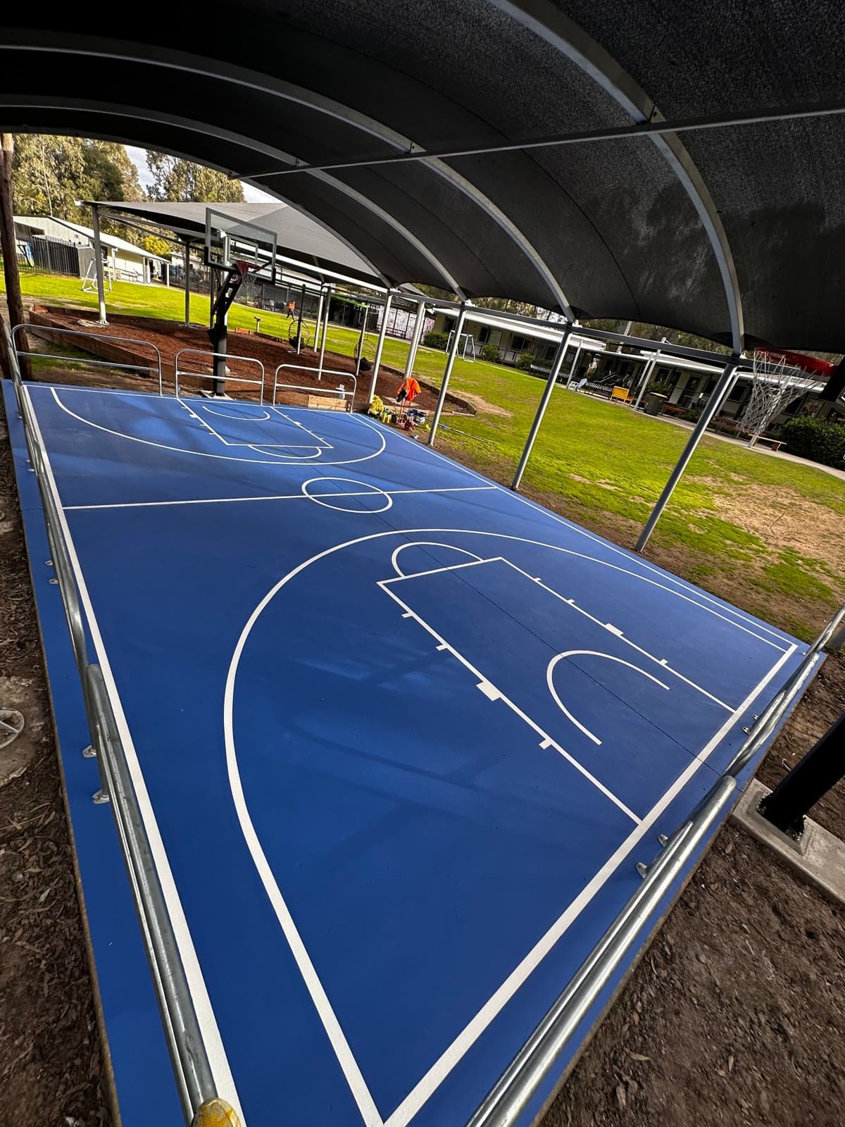 Deep blue court surface and white line marking under the new covered structure