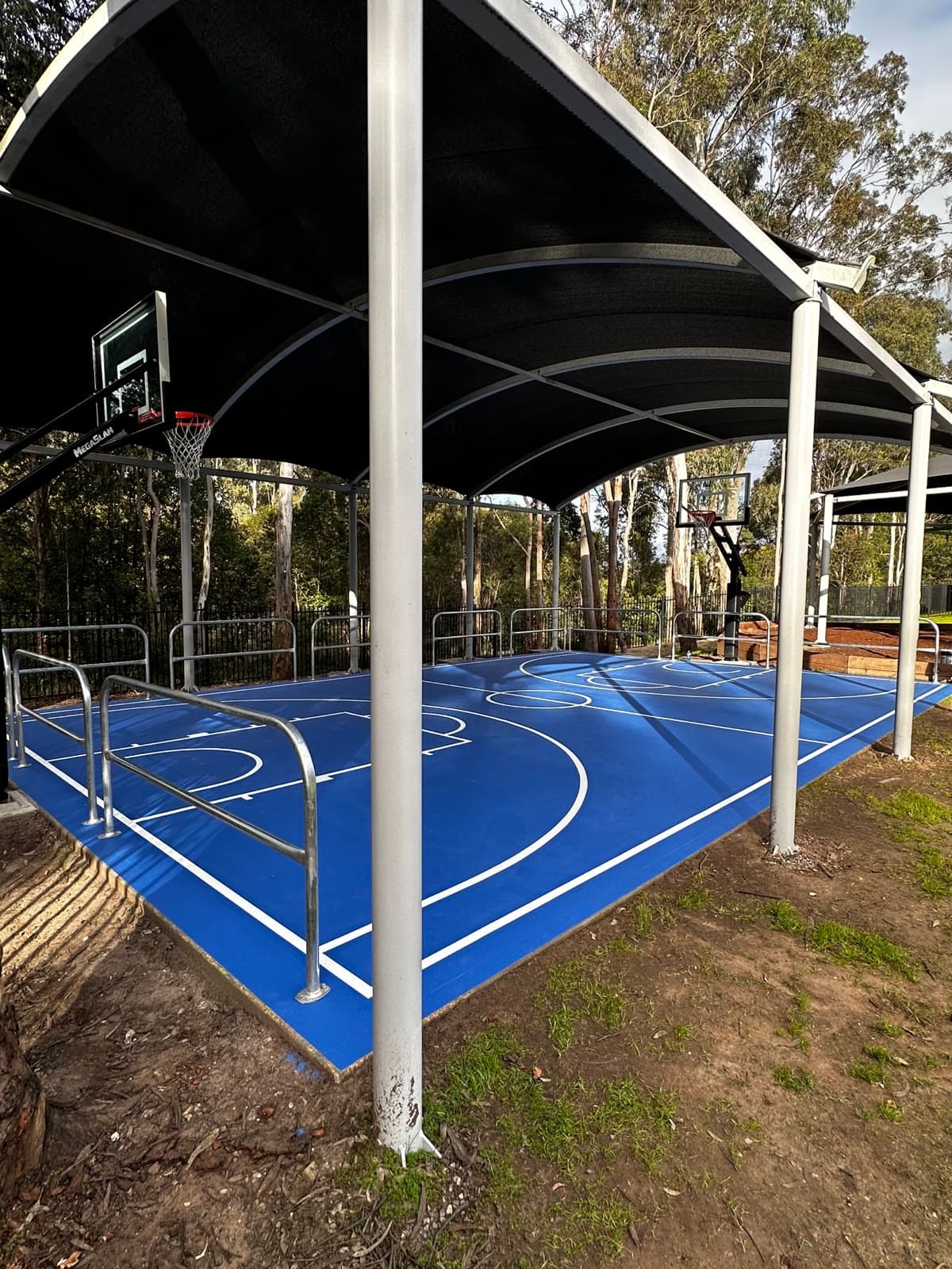The court from the corner, showing the arched cover, both backboards and the surrounding trees