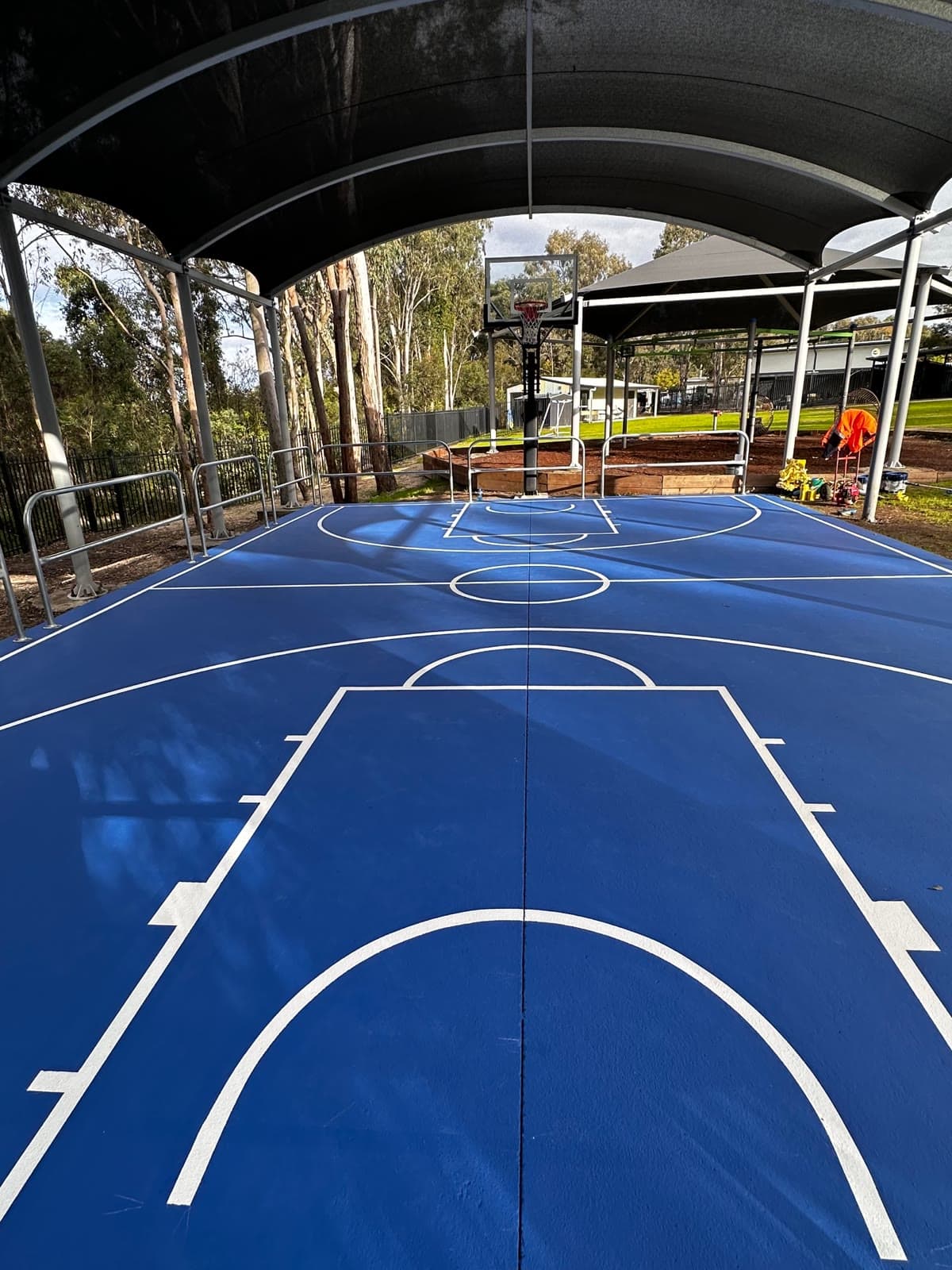 Full court length under the curved cover, looking towards the far hoop