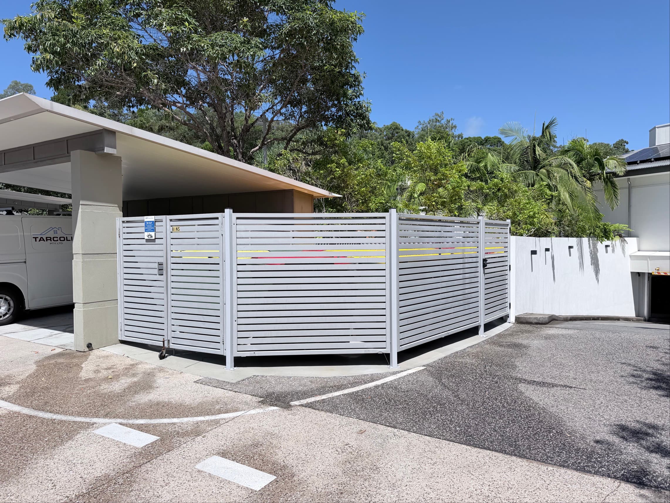 Completed bin enclosure at a Noosa resort - aluminium louvre fencing and gates with tropical resort setting