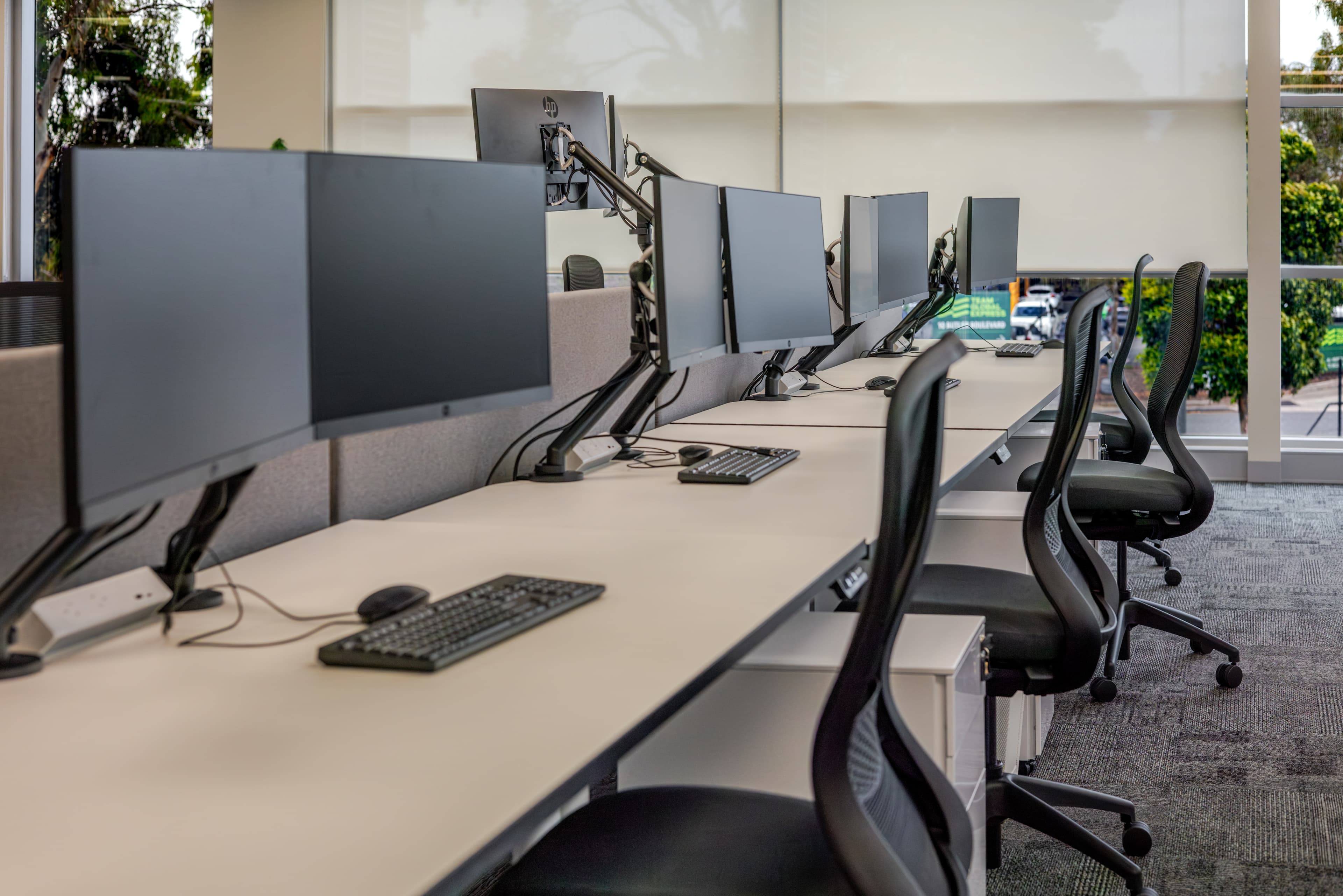 Open-plan workstation run with dual-monitor arm setups